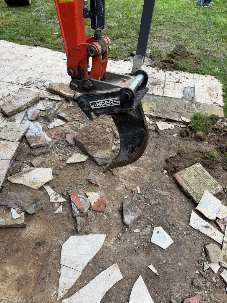 Minibagger bei Abrissarbeiten für eine neue Gartenanlage in Mönchengladbach