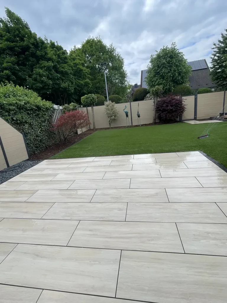 Keramikterrasse 40 m² in Mönchengladbach in heller Travertinoptik mit Rasenkante und Sichtschutzzaun